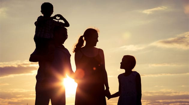 happy-family-standing-on-the-field-at-the-sunset-PPCT7EZ